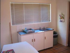 a small kitchen with a sink and a window at Korentepoort Dam in Riversdale +50 photos
