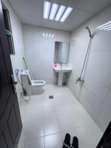 a bathroom with a toilet and a sink at Holiday Abu Dhabi in Abu Dhabi
