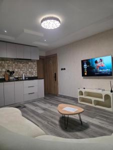 ein Wohnzimmer mit Sofa und Fernseher an der Wand in der Unterkunft Haus in Enugu