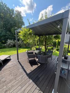 eine Terrasse mit Tisch und Stühlen unter einem Sonnensegel in der Unterkunft Silja in Pärnu