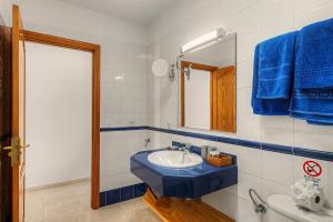 a bathroom with a blue sink and a mirror at Callao Beach 10 in Arrieta +16 photos