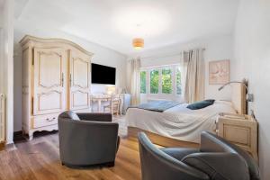 a bedroom with a bed and chairs and a table at Villa Rêve d'Azur in Grasse