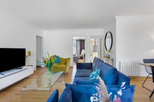a living room with a blue couch and a tv at La Parenthèse Paimpolaise in Paimpol