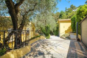 a driveway with a fence and a tree at Villa Rêve d'Azur in Grasse