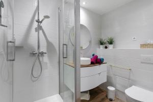 a white bathroom with a shower and a sink at La Parenthèse Paimpolaise in Paimpol +17 photos
