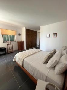 a bedroom with a large bed with white sheets and pillows at Sunset Ria in Tavira
