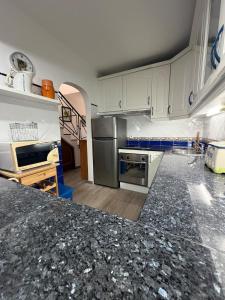 a kitchen with white cabinets and a black counter top at Sunset Ria in Tavira