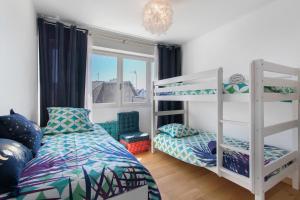 a bedroom with two bunk beds and a window at La Parenthèse Paimpolaise in Paimpol
