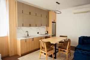 a kitchen and dining room with a wooden table and chairs at Rooftop Apartment with Garden and Jacuzzi in Durrës