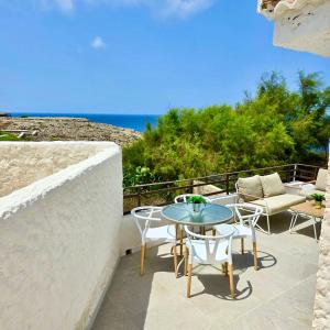 a patio with a table and chairs and the ocean at Casa LUZ - Vivir en turquesa in Cala en Forcat