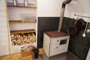 a kitchen with a stove and a pile of wood at S'Platzl in Wenns +5 photos