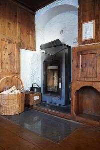 a living room with a fireplace and a basket at S'Platzl in Wenns