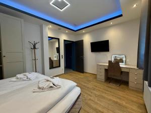 a room with two beds and a desk and a television at Hotel Montenegro in Worms