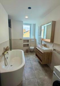a bathroom with a tub and a sink and a toilet at Hotel Montenegro in Worms