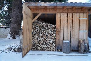 a wooden shed with a pile of fire wood at S'Platzl in Wenns