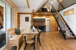 a living room with a dining room table and a staircase at Pension Ferienwohnung Baarblick in Donaueschingen