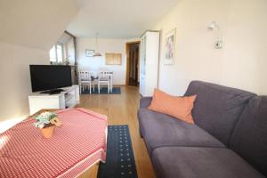 a living room with a couch and a tv at Hotel garni Zur Post in Utersum