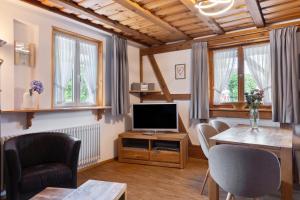a living room with a tv and a table and chairs at Pension Ferienwohnung Baarblick in Donaueschingen
