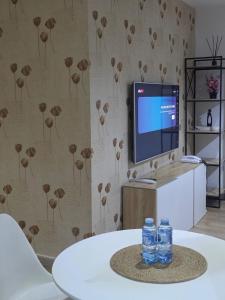 Zwei Flaschen Wasser stehen auf einem Tisch vor einem Fernseher. in der Unterkunft Haus in Enugu