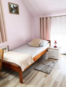 a bedroom with a bed and a dresser and a window at Pokoje gościnne u Antka in Krynki