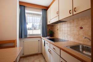 a small kitchen with a sink and a window at Residence Alpenrose in Sesto +16 photos
