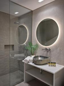 a bathroom with a sink and two mirrors at Sunset Rocks Residence in Parasporos
