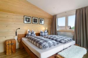 a bedroom with two beds and a wooden wall at Pension Ferienwohnung Baarblick in Donaueschingen
