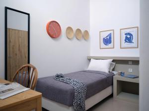 a bedroom with a bed and a desk and a clock at Sunset Rocks Residence in Parasporos