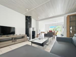 a living room with a couch and a table at L'Abri Côtier, maison spacieuse avec jardin in Pendé