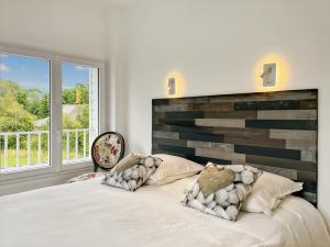 a bedroom with a large bed and a large window at L'Abri Côtier, maison spacieuse avec jardin in Pendé
