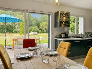 a kitchen with a wooden table with wine glasses on it at L'Abri Côtier, maison spacieuse avec jardin in Pendé