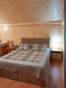 a bedroom with a bed with a wooden wall at Otto's House in Ambrolauri