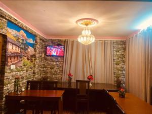 a dining room with a table and a tv on a wall at Hotel New Bhojpure in Kathmandu