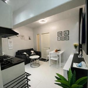 a kitchen and living room with a couch and a table at Mely's Condotel Mactan in Mactan Island