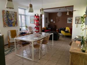 a dining room and living room with a table and chairs at Maison de campagne in Chièvres