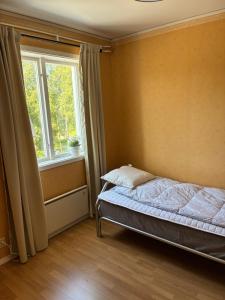 a bedroom with a bed and a window at Strandvillan in Älandsbro
