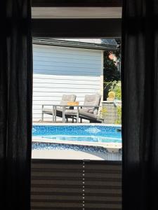 Blick auf einen Pool mit zwei Stühlen und einem Tisch in der Unterkunft Silja in Pärnu