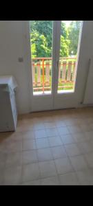 an empty room with an open door to a balcony at Paradis Oyonnax in Bellignat