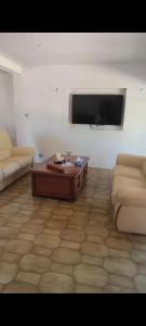 a living room with a couch and a table and a tv at Paradis Oyonnax in Bellignat