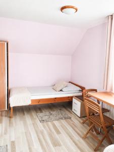 a room with a bed and a table and a desk at Pokoje gościnne u Antka in Krynki +3 photos