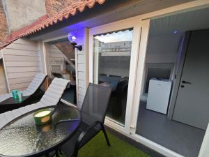 a patio with a table and chairs on a balcony at Chambre confortable 2P avec Terasse in Ostend