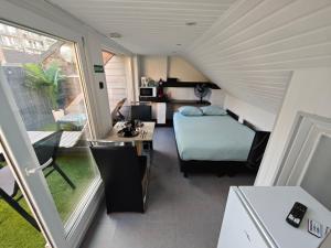 a room with a bed and a desk in a tiny house at Chambre confortable 2P avec Terasse in Ostend