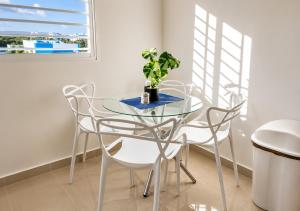 a glass table with two chairs and a potted plant at Tropical Pearl Getaway in Los Paredones