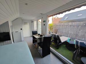 a room with a table and chairs and a large window at Chambre confortable 2P avec Terasse in Ostend