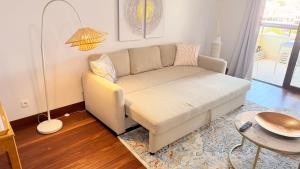 a living room with a couch and a table at Seaside one bedroom apartment with terraces, garage & swimming pool in Cascais +74 photos