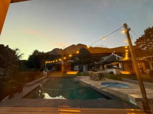a swimming pool in a yard with a house at Novelle Vista Cottage in Hout Bay