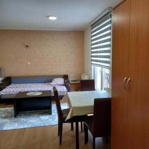 a room with a table and a bed and a dining room at Apartmani Aleksijević Zlatibor in Zlatibor