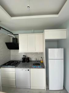 a kitchen with white cabinets and a white refrigerator at TURKERHOMe in Ordu