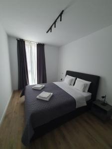 a bedroom with a bed with two towels on it at Sterling House in Timişoara