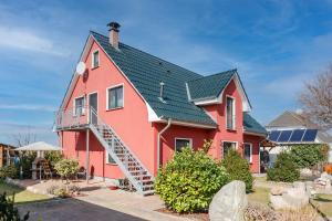 a large red house with a metal roof at Ferienwohnung Thurbruch in Zirchow